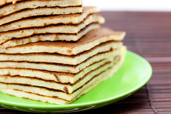 Pfannkuchen auf einem Teller auf einer Bambusmatte — Stockfoto