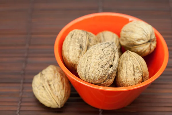 Орехи в миске на бамбуковом коврике — стоковое фото