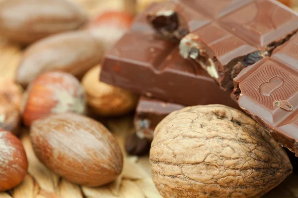 Bar of chocolate and nuts on a wicker mat