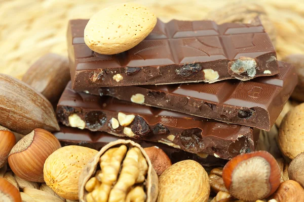 Bar čokolády a ořechů na proutěné rohože — Stock fotografie
