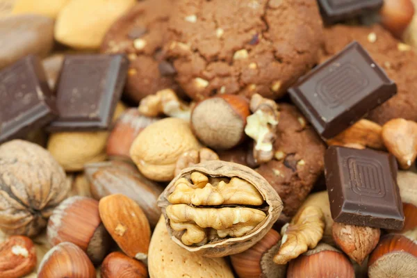 Haferflocken-Kekse, Schokolade und Nüsse auf einer Weidenmatte — Stockfoto