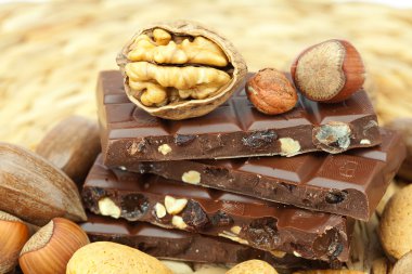 Bar of chocolate and nuts on a wicker mat