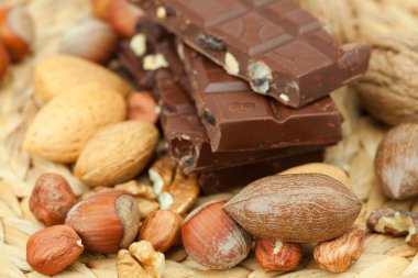 Bar of chocolate and nuts on a wicker mat