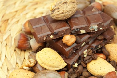 Bar of chocolate and nuts on a wicker mat