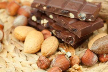 Bar of chocolate and nuts on a wicker mat