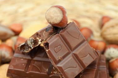 Bar of chocolate and nuts on a wicker mat