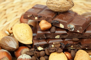 Bar of chocolate and nuts on a wicker mat