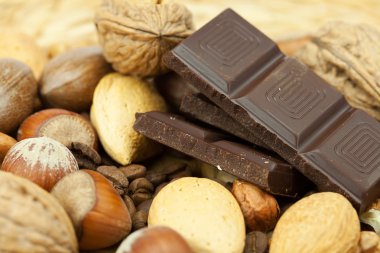 Bar of chocolate and nuts on a wicker mat