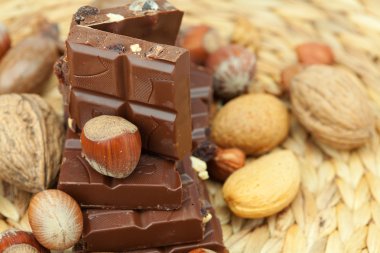 Bar of chocolate and nuts on a wicker mat