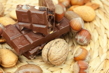 Bar of chocolate and nuts on a wicker mat