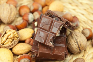 Bar of chocolate and nuts on a wicker mat