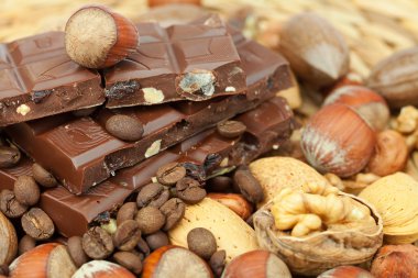 Bar of chocolate and nuts on a wicker mat