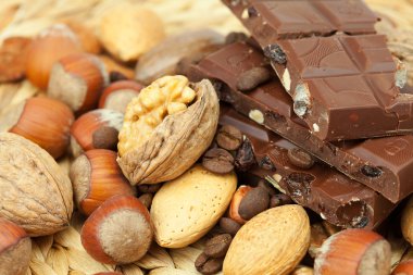 Bar of chocolate and nuts on a wicker mat