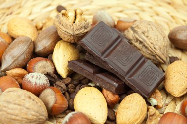 Bar of chocolate and nuts on a wicker mat