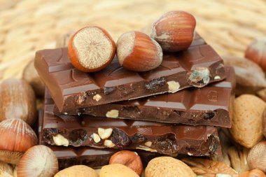 Bar of chocolate and nuts on a wicker mat