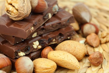 Bar of chocolate and nuts on a wicker mat