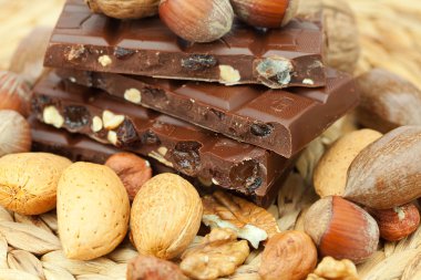 Bar of chocolate and nuts on a wicker mat