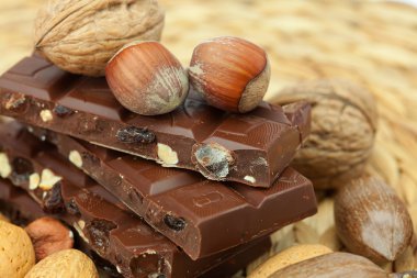 Bar of chocolate and nuts on a wicker mat