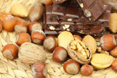 Bar of chocolate and nuts on a wicker mat