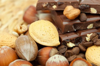 Bar of chocolate and nuts on a wicker mat