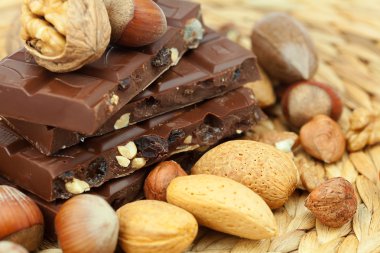 Bar of chocolate and nuts on a wicker mat