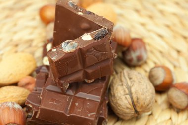 Bar of chocolate and nuts on a wicker mat