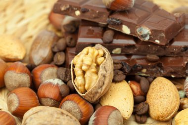 Bar of chocolate and nuts on a wicker mat