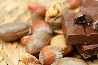 Bar of chocolate and nuts on a wicker mat