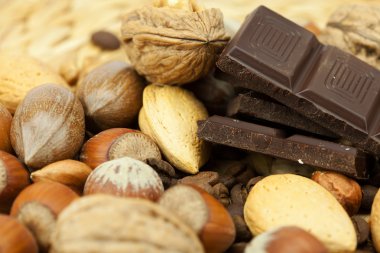 Bar of chocolate and nuts on a wicker mat