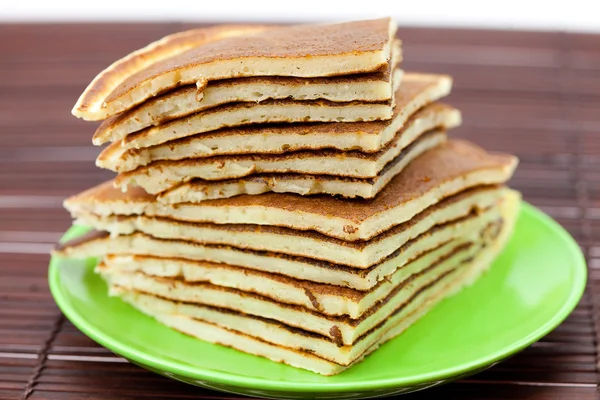 Pancakes on a plate on a bamboo mat — Stock Photo, Image