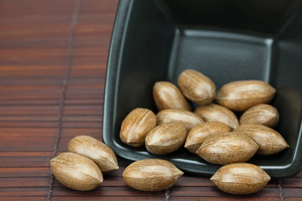 Pekanové ořechy v misce na bambusové rohoži — Stock fotografie