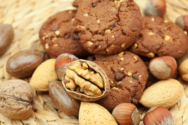 Oatmeal cookies and nuts in a wicker mat — Stock Photo, Image