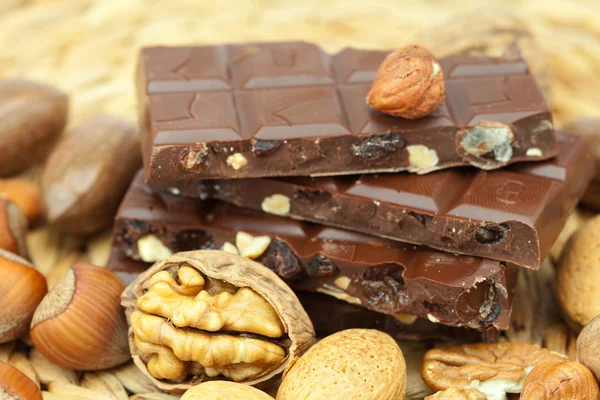 Barra de chocolate y nueces en una estera de mimbre —  Fotos de Stock