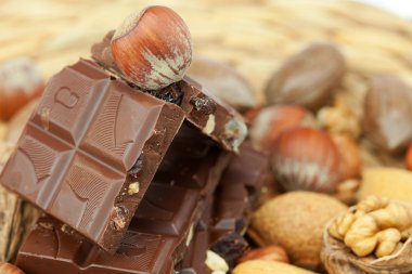 Bar of chocolate and nuts on a wicker mat