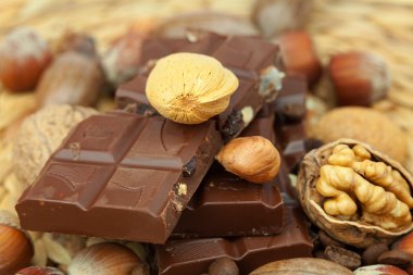 Bar of chocolate and nuts on a wicker mat