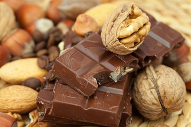 Bar of chocolate and nuts on a wicker mat