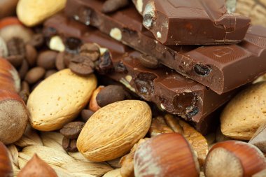 Bar of chocolate and nuts on a wicker mat