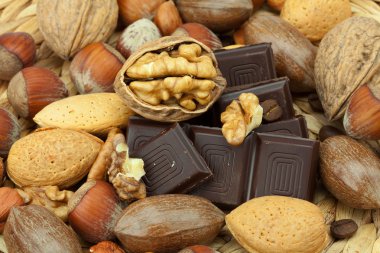 Bar of chocolate and nuts on a wicker mat