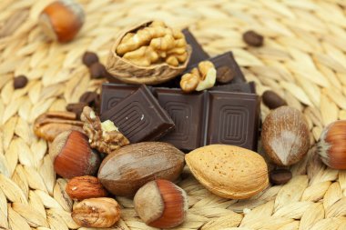 Bar of chocolate and nuts on a wicker mat