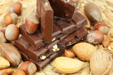 Bar of chocolate and nuts on a wicker mat