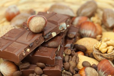 Bar of chocolate and nuts on a wicker mat