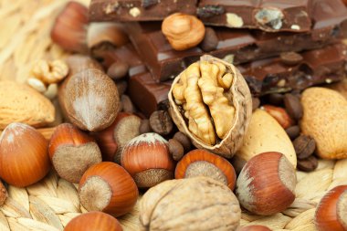 Bar of chocolate and nuts on a wicker mat