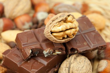 Bar of chocolate and nuts on a wicker mat