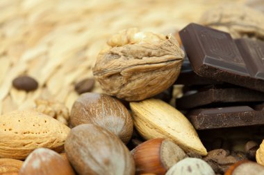 Bar of chocolate and nuts on a wicker mat