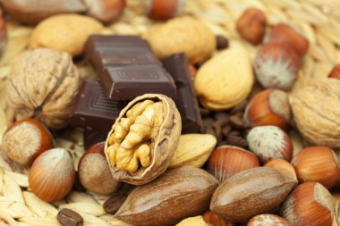 Bar of chocolate and nuts on a wicker mat