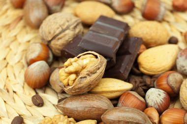 Bar of chocolate and nuts on a wicker mat