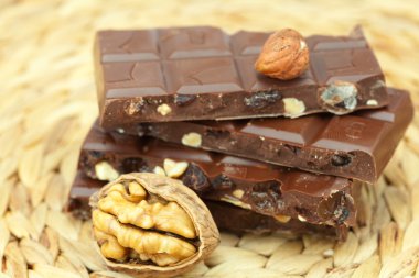 Bar of chocolate and nuts on a wicker mat