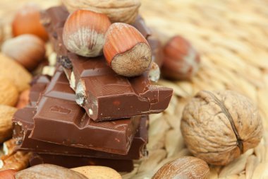 Bar of chocolate and nuts on a wicker mat