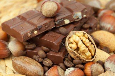 Bar of chocolate and nuts on a wicker mat