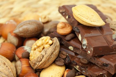 Bar of chocolate and nuts on a wicker mat